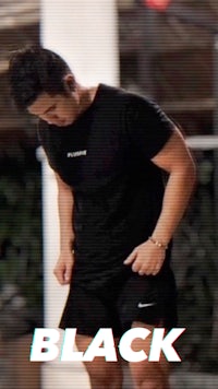 a man wearing a black t - shirt and shorts