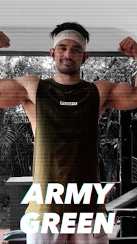 a man posing in front of a gym with the words army green